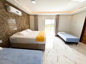 a hotel room with two beds and a window at Eficiência - Casa Recanto dos Ventos in Camocim +55 photos