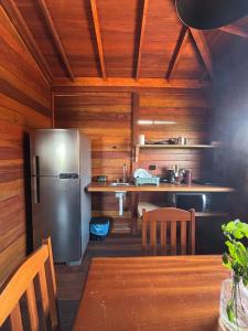 uma cozinha com uma geladeira de aço inoxidável e uma mesa em Canto do Mar - Atins - Lençóis Maranhenses em Atins