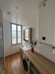 a bathroom with a sink and a washing machine at Côté Aisne - vue imprenable in Soissons