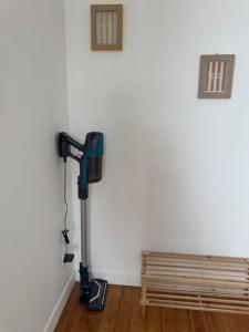 a room with a vacuum next to a wooden bench at Côté Aisne - vue imprenable in Soissons