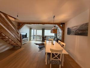 a dining room and living room with a table and chairs at Ferienwohnung Leni in Siegsdorf