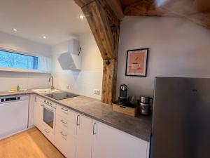 a kitchen with white cabinets and a black refrigerator at Ferienwohnung Leni in Siegsdorf