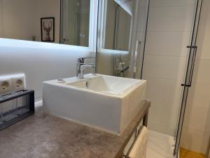 a bathroom with a white sink and a shower at Ferienwohnung Leni in Siegsdorf +31 photos