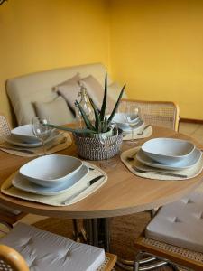 einem Holztisch mit Tellern und Geschirr darauf in der Unterkunft Domaine Wagenbourg à Soultzmatt in Soultzmatt + 9 Fotos