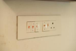 6 Elements Bedrooms With Event Space 4500 Sq Ft في تريفاندروم: مفتاح إضاءة أبيض على جدار أبيض