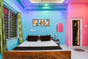 Hotel O Subharaj palace 2 في كولْكاتا: غرفة نوم بسرير بجدران زرقاء وردية