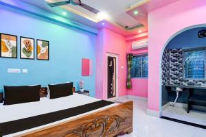 Hotel O Subharaj palace 2 في كولْكاتا: غرفة نوم بجدران وردية وزرقاء وسرير