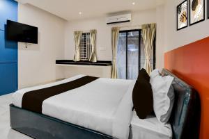 a bedroom with a large bed and a television at Hotel O Infocity Square Road Bhubaneswar Formerly Avigna Premium in Bhubaneshwar