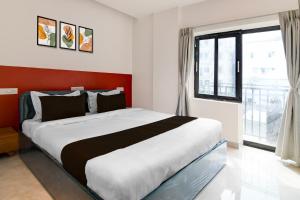 Un dormitorio con una cama grande y una ventana grande en Super Hotel O Avigna Premium, en Bhubaneshwar 19 fotos más