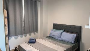 a small bedroom with a bed with blue pillows at Studio c Piscina e Academia | A 13 Min de Copa in Rio de Janeiro +83 photos