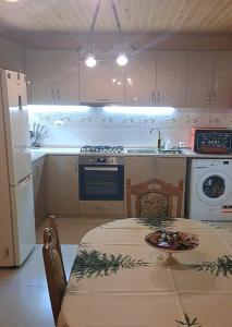 a kitchen with a table and a white refrigerator at olya's garden in Itʼkhvisi