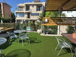 a patio with tables and chairs on the grass at Vivaldi Suites in Villa Carlos Paz