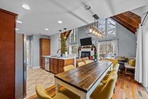 eine Küche und ein Wohnzimmer mit einem Holztisch und Stühlen in der Unterkunft Cozy Family Getaway w Games Hot Tub & Fire Pit in Bryson City