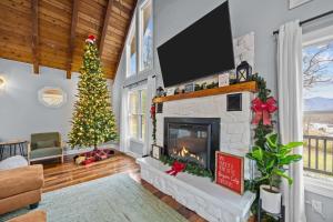 ein Wohnzimmer mit einem Weihnachtsbaum und einem Kamin in der Unterkunft Cozy Family Getaway w Games Hot Tub & Fire Pit in Bryson City + 50 Fotos