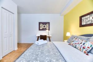 een slaapkamer met een kingsize bed en gele muren bij NDG & Montreal getaway in Montreal