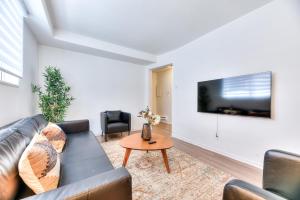 een woonkamer met een bank en een tv aan de muur bij NDG & Montreal getaway in Montreal