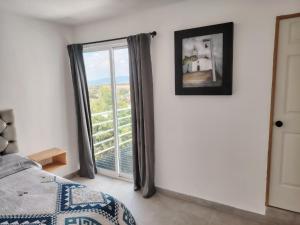 una camera da letto con un letto e una porta scorrevole in vetro di Mini Hotel El Mezquite a Villa Doctor Mora