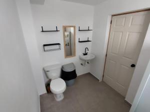 un bagno bianco con un water e un lavandino di Mini Hotel El Mezquite a Villa Doctor Mora