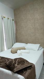 Un dormitorio con dos camas con sábanas blancas y toallas. en Hotel Familiar, en Salinas