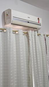 Una secadora está colocada encima de una cortina de ventana. en Hotel Familiar, en Salinas