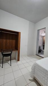 Un dormitorio con una cama y un escritorio sobre un suelo de baldosas. en Hotel Familiar, en Salinas