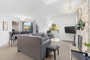 a living room with a couch and a fireplace at Modern Home with Forested Views by Harmony Whistler in Whistler