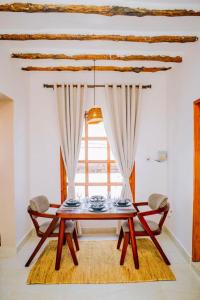 a table and chairs in a room with a window at Manzi Hub Residence in Zanzibar City