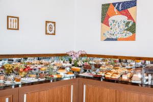 a buffet line with many different types of food at Hotel Santa Maria by RB Hotelaria in Campo Mourão