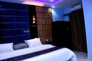 Dreamville Hotel & Resort في أويو: غرفة نوم بسرير كبير وجدار أزرق