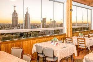 a restaurant with tables and a view of the clock tower at Hotel Santa Maria by RB Hotelaria in Campo Mourão