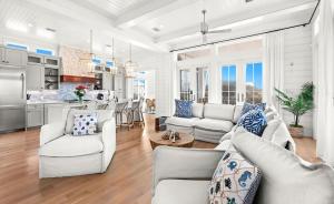 a living room with white furniture and a kitchen at Pomp in Paradise in Inlet Beach