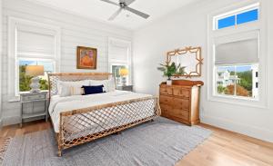 a bedroom with a bed and a dresser and windows at Pomp in Paradise in Inlet Beach +69 photos