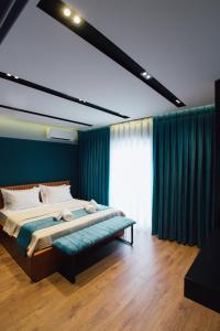 ein Schlafzimmer mit einem großen Bett mit einer blauen Wand in der Unterkunft Brilant Luxury Apartment in Gjirokastër