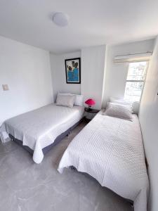 En eller flere senge i et værelse på Apartamento Rodadero Playa