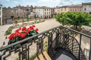 a balcony with a bunch of red flowers on it at Place Carnot in Tournus