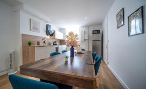 a dining room with a wooden table and blue chairs at Place Carnot in Tournus