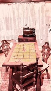 Descanso y trabajo con jardín en Barrio Carrasco في مونتيفيديو: طاولة خشبية في المطبخ مع محمصة الخبز