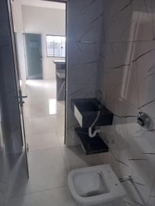 a bathroom with a white toilet in a room at Casa Proxima do Centro in Primavera do Leste