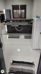 a kitchen with a tile floor with a refrigerator at Casa Proxima do Centro in Primavera do Leste