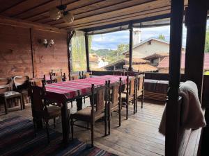 een eetkamer met een tafel en stoelen op een terras bij Мандулова Къща in Koprivshtitsa
