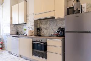 a kitchen with white cabinets and a refrigerator at SOGNI sul MARE-5 TERRE JRE in La Spezia