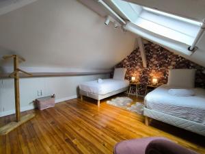 a attic room with two beds and a table at Splendid T4 - Spacious - Air conditioning - 6 People in Pau
