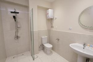 ein Badezimmer mit Dusche, Toilette und Waschbecken in der Unterkunft Settle Inn Banafseg Apartments in Kairo