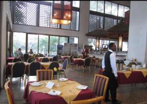 a man standing in a dining room with tables at Tana hotel in Bahir Dar +31 photos