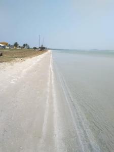 una spiaggia sabbiosa con l'acqua in lontananza di Casa Verde ad Arraial do Cabo