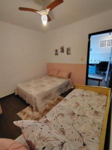 una camera da letto con due letti e un ventilatore a soffitto di Casa Verde ad Arraial do Cabo Altre 16 foto