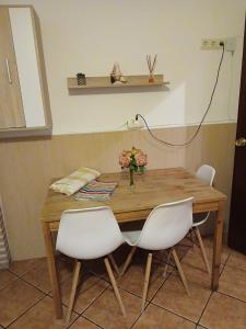 a wooden table with two chairs and a vase on it at Mallona in Pedro Rodríguez