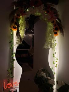 un vaso con fiori davanti a uno specchio di Casa Café Cacao a San Pedro Las Huertas