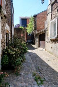 een steegje in een oud gebouw met een stenen stoep bij Les Reflets de Meuse in Revin