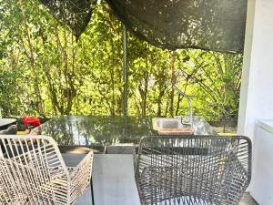 a table and chairs on a patio with trees at Casa finca platanales in Cartagena de Indias